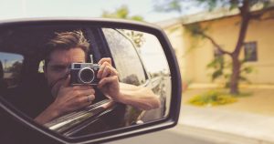 Man taking picture while sitting in moving car